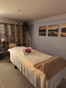 Relaxing massage room with prepared treatment table, pillows, blanket, and zen decor