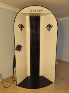 Standing tanning booth with ST. TROPEZ branding