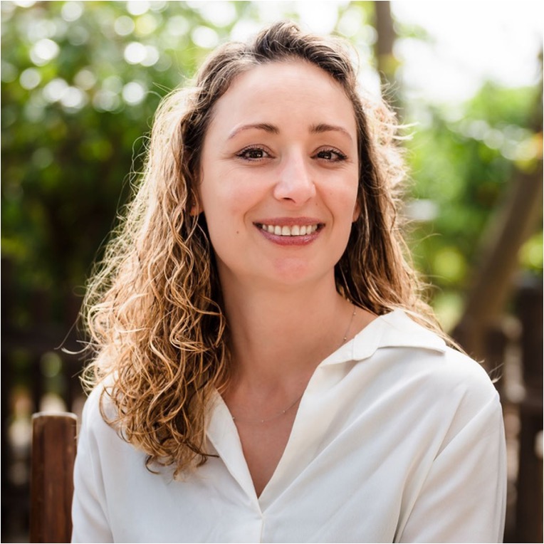 Woman named Ivayla Vassileva with curly blonde hair wearing a white shirt